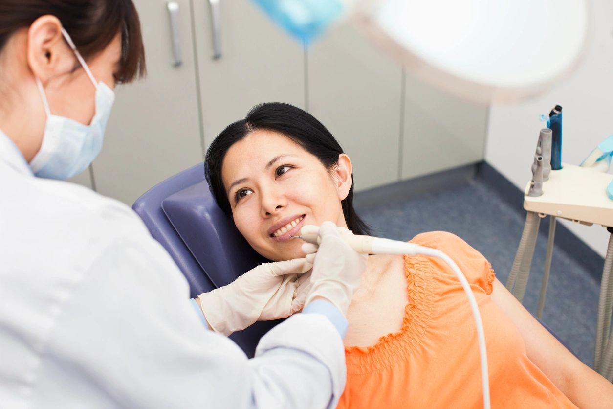 Woman receiving dental treatment from a dentist.