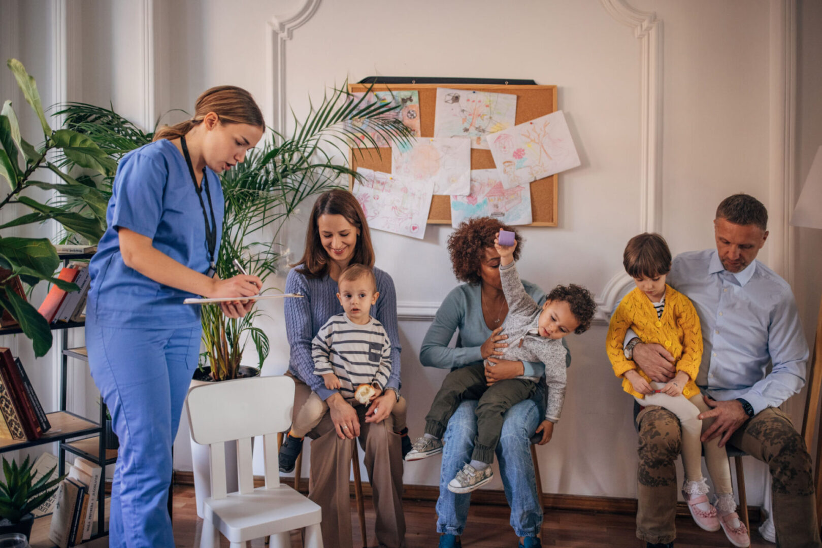 Children with parents and nurse in waiting room.